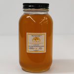 Wildflower raw honey jar from The Fat Lady with a golden honey color, labeled for skincare and cooking, in a natural setting.